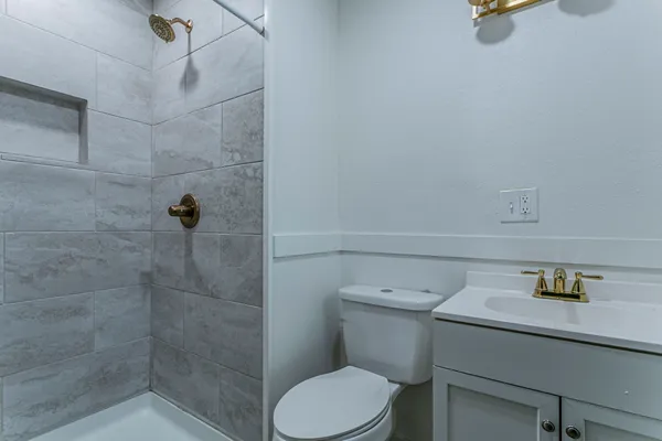 a bathroom with a shower a toilet and a sink