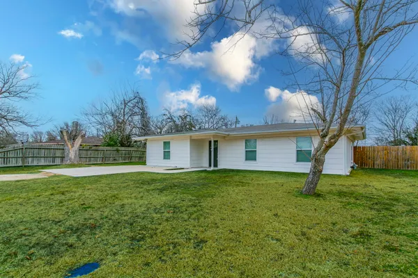 a house is sitting in middle od the grass