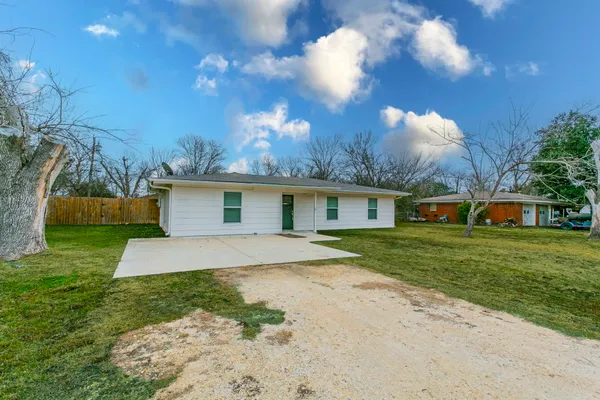 a front view of a house with a yard and trees
