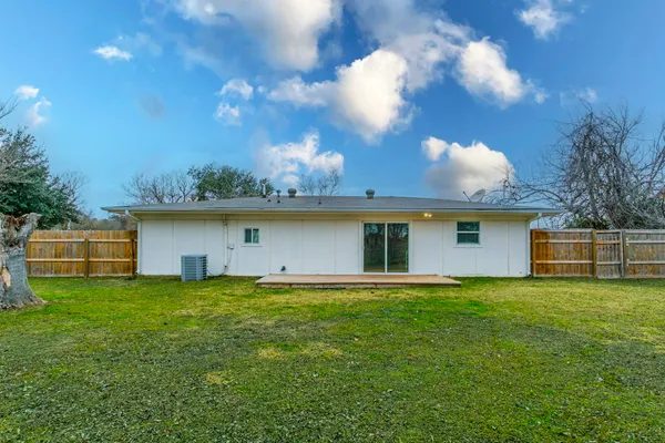 a view of a house with a yard and a tree