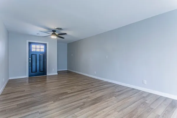 a view of an empty room with wooden floor