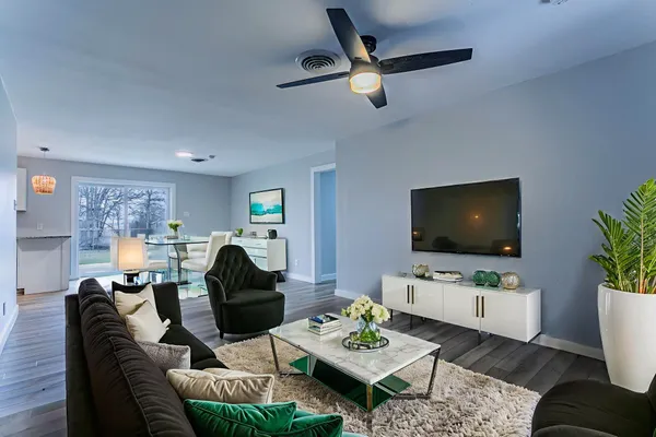 a living room with furniture a flat screen tv and a potted plant