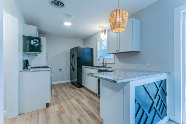 a kitchen with refrigerator a microwave a stove and a cabinets