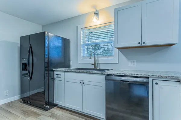a kitchen with stainless steel appliances granite countertop a sink and a refrigerator