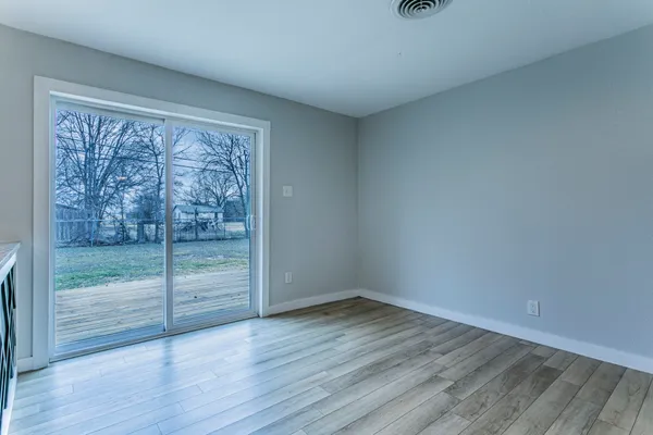 a view of a room with wooden floor and sliding window