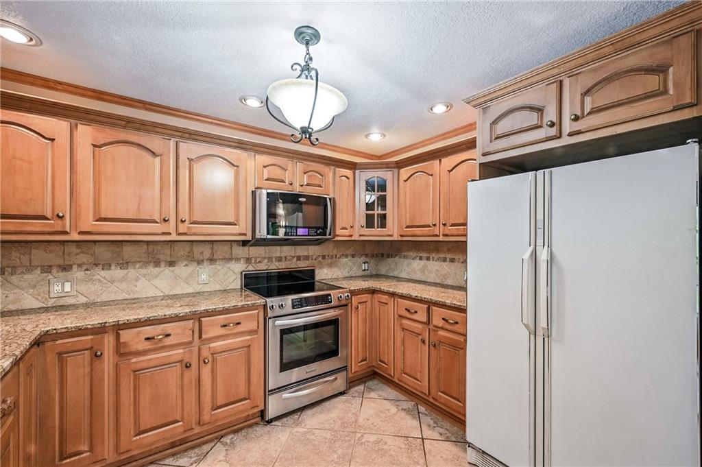 301 Hopper Road Transfer, PA 16154 - Photo 22 of 48 a kitchen with stainless steel appliances granite countertop a refrigerator oven a sink dishwasher and white cabinets with wooden floor