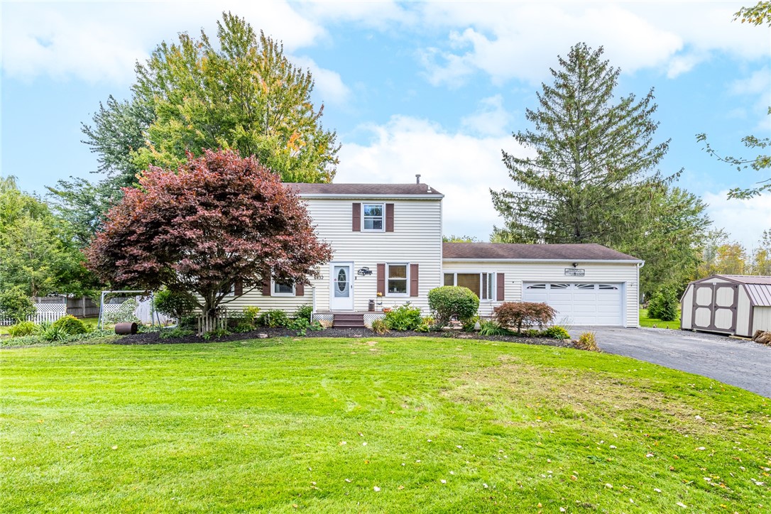 Mature trees frame this classic multi-level residence featuring an attached garage and expansive front lawn.