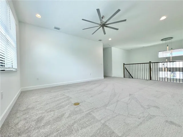 an empty room with fan and windows
