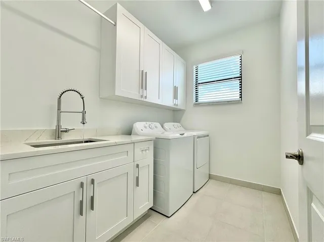 a utility room with cabinets washer and dryer