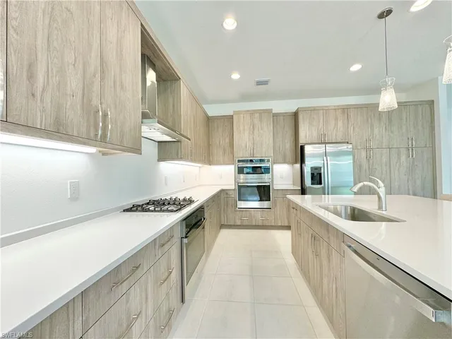 a kitchen with stainless steel appliances granite countertop a sink and a refrigerator