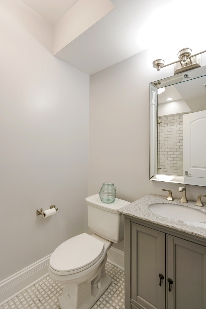 9 North Ada Street Chicago, IL 60607 - Photo 24 of 39 a bathroom with a granite countertop sink a toilet and a mirror