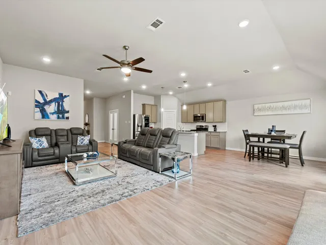 a living room with furniture and kitchen view