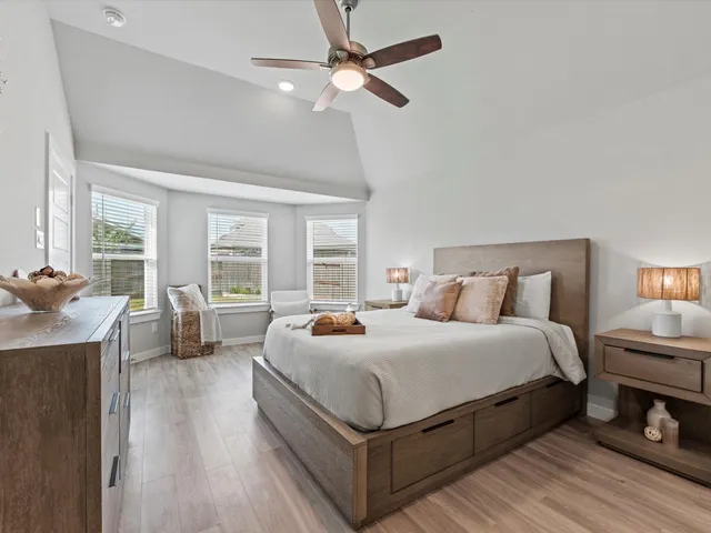 a bedroom with bed a table and a large window