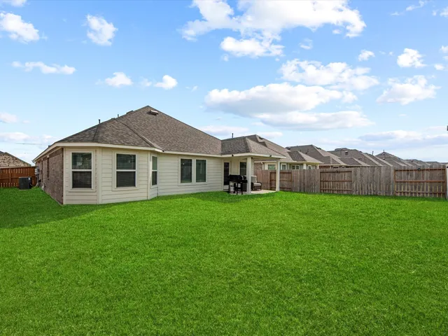 a view of a yard in front of a house with a large tree