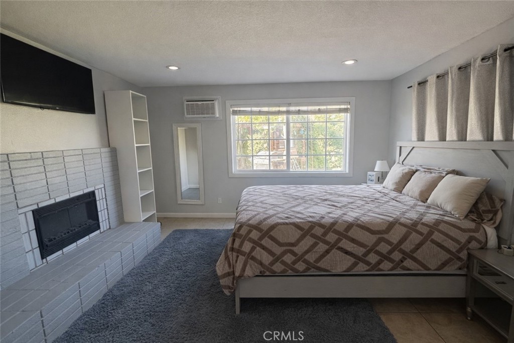 8943 Delano Drive Riverside, CA 92503 - Photo 8 of 12 a bedroom with a bed a flat screen tv and windows