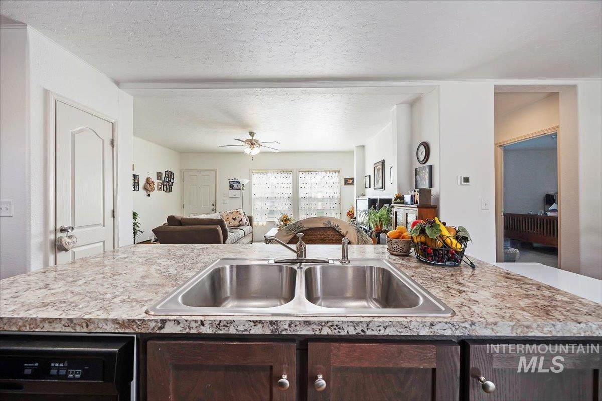 121 Sunset Drive North Hagerman, ID 83332 - Photo 30 of 31 Kitchen featuring light countertops, dark brown cabinets, a textured ceiling, a ceiling fan, and open floor plan