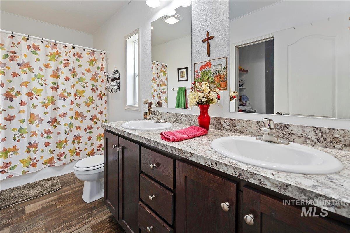 121 Sunset Drive North Hagerman, ID 83332 - Photo 17 of 31 Full bath with double vanity, dark wood-style flooring, and shower / tub combo