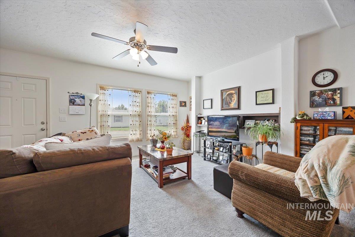 121 Sunset Drive North Hagerman, ID 83332 - Photo 5 of 31 Living room featuring a textured ceiling, carpet, and ceiling fan