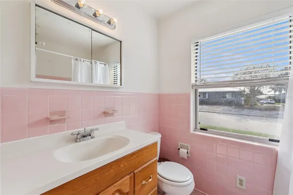 a bathroom with a sink toilet mirror and tub