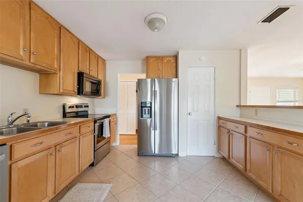 a kitchen with stainless steel appliances granite countertop a refrigerator and a stove top oven
