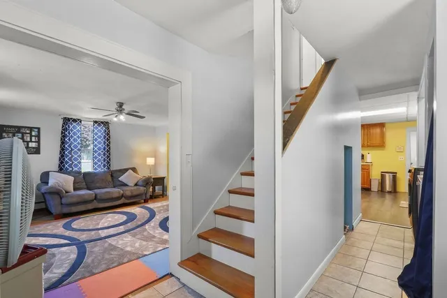 a living room with furniture and a dining table with wooden floor