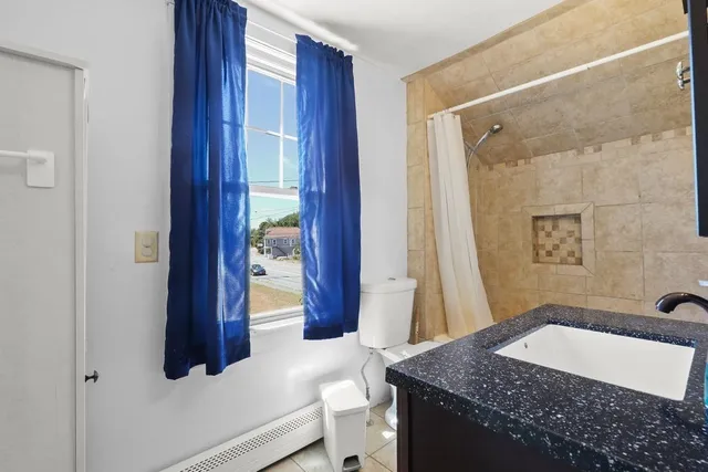 a bathroom with a granite countertop sink a toilet and shower