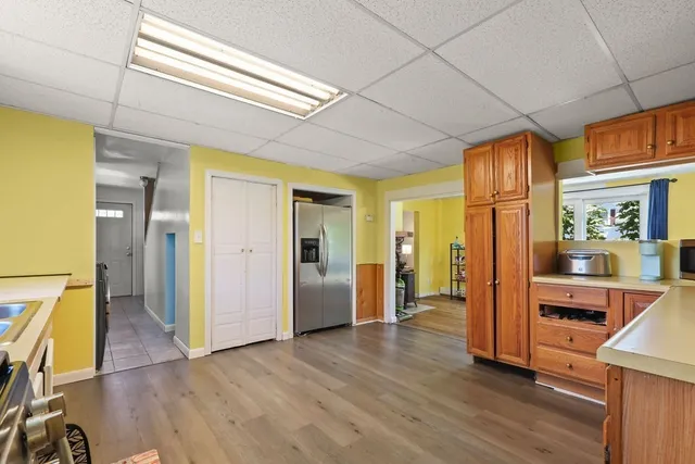a view of a hallway with wooden floor and cabinet