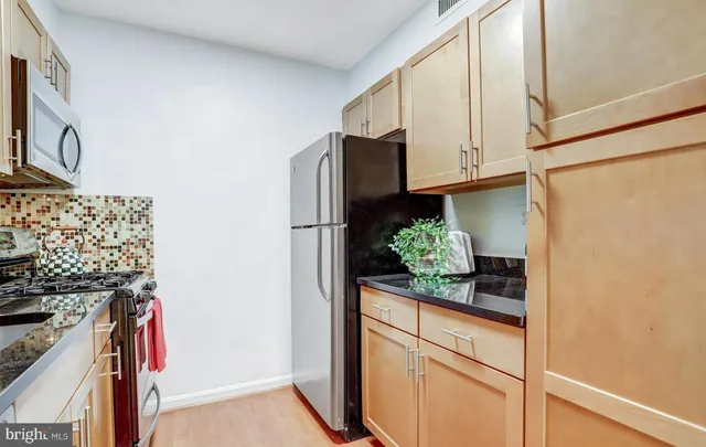 a kitchen with stainless steel appliances granite countertop a refrigerator and a stove