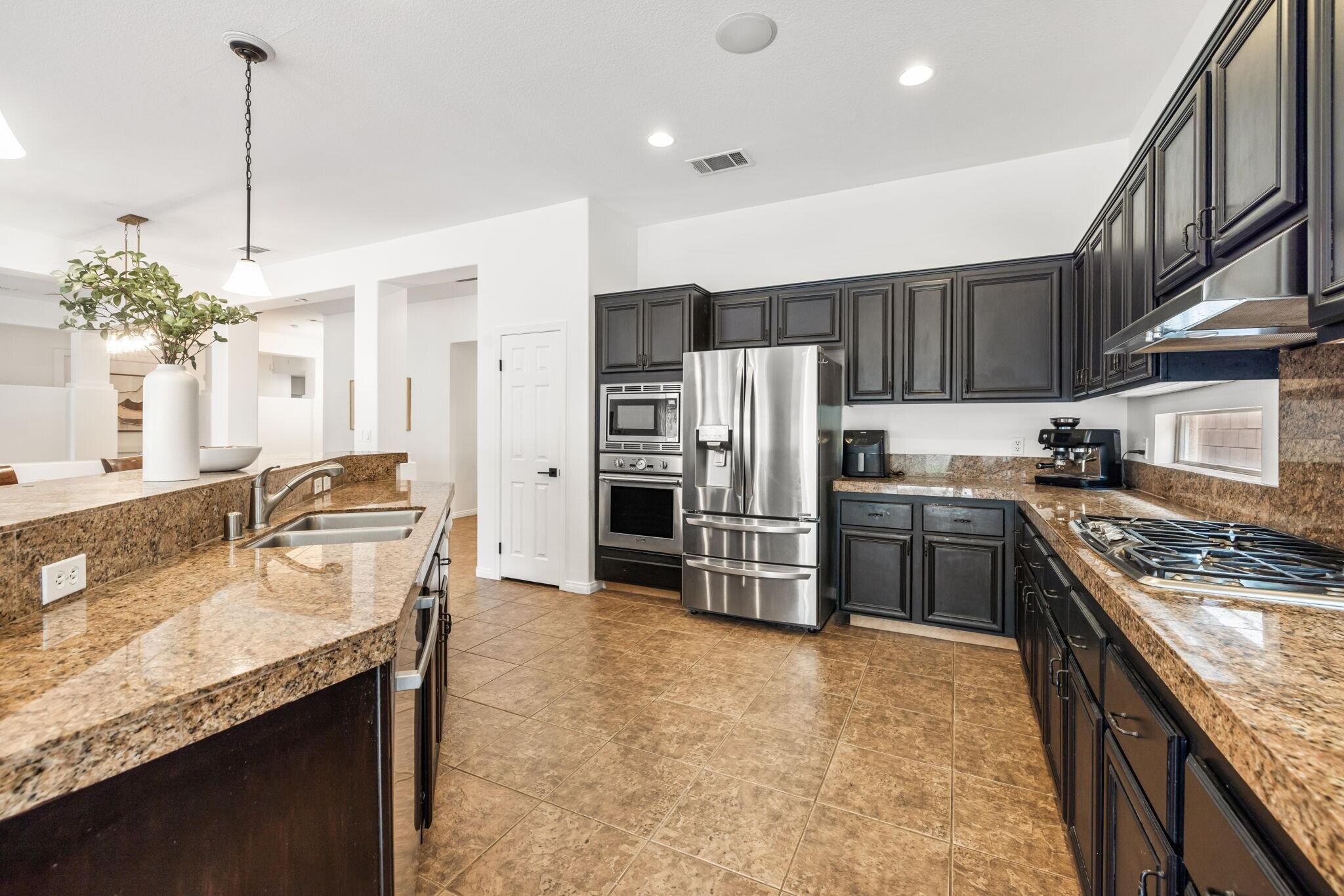 80543 Philadelphia Avenue Indio, CA 92201 - Photo 17 of 46 a kitchen with refrigerator a stove and a sink