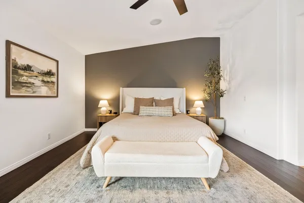 a bedroom with a bed and a painting on the wall