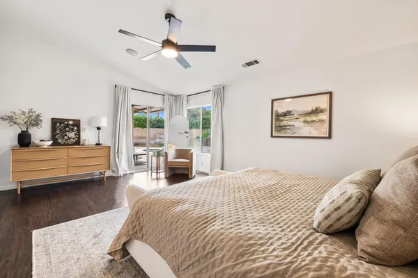 a spacious bedroom with a bed a couch and a chandelier