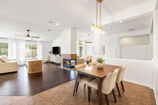 a view of a dining room and livingroom with furniture wooden floor a chandelier