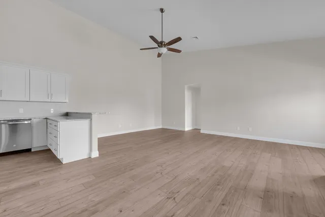 a view of empty room with wooden floor