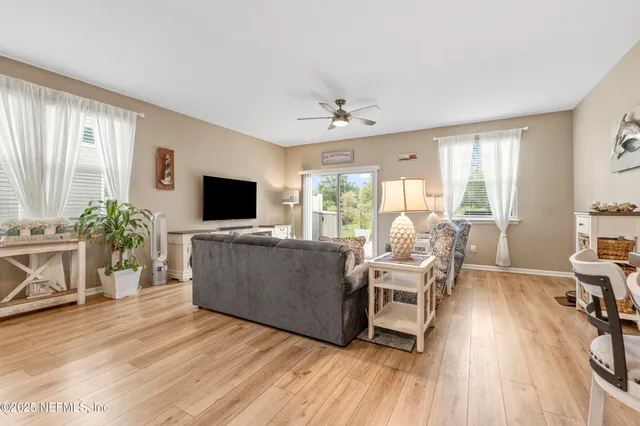 a living room with furniture a flat screen tv and a large window