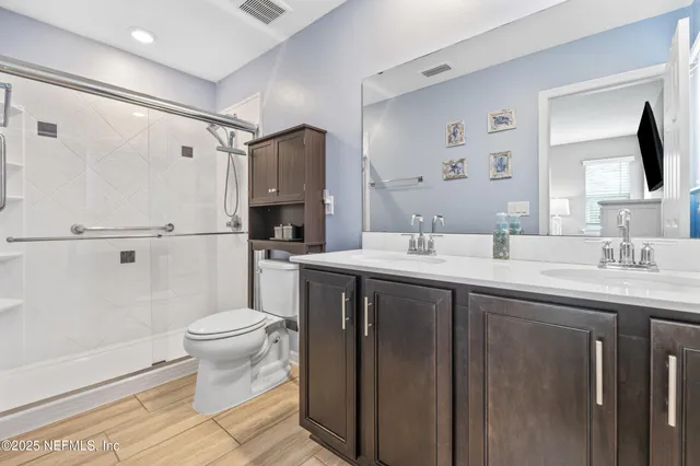 a bathroom with a sink toilet a mirror and shower