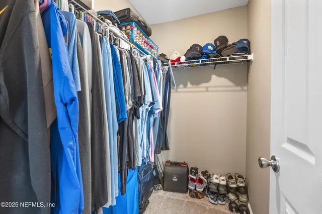 a view of walk in closet with clothes