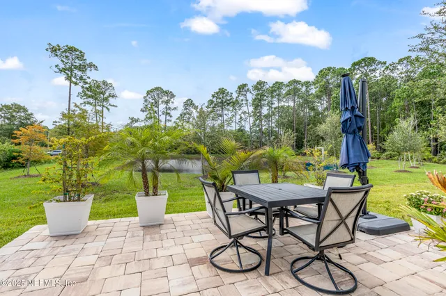 a view of a patio with table and chairs potted plants with wooden fence