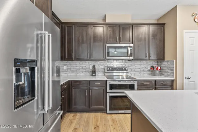 a kitchen with kitchen island granite countertop wooden cabinets and a stove top oven