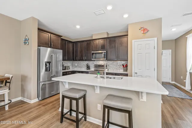 a kitchen with kitchen island a refrigerator stove and microwave