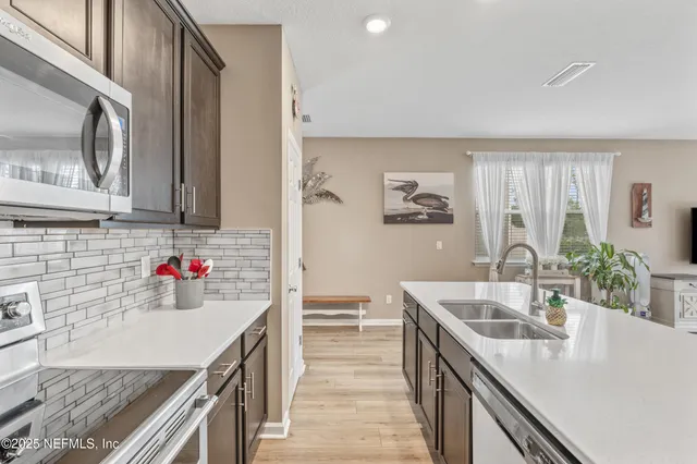 a kitchen with a sink dishwasher a stove and a refrigerator with wooden floor