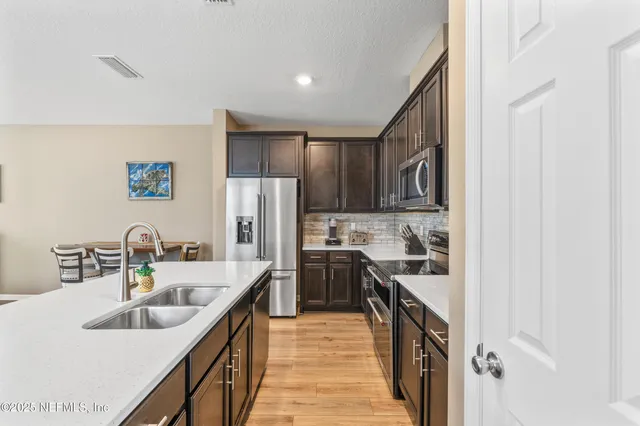 a kitchen with kitchen island granite countertop a sink stove refrigerator and cabinets