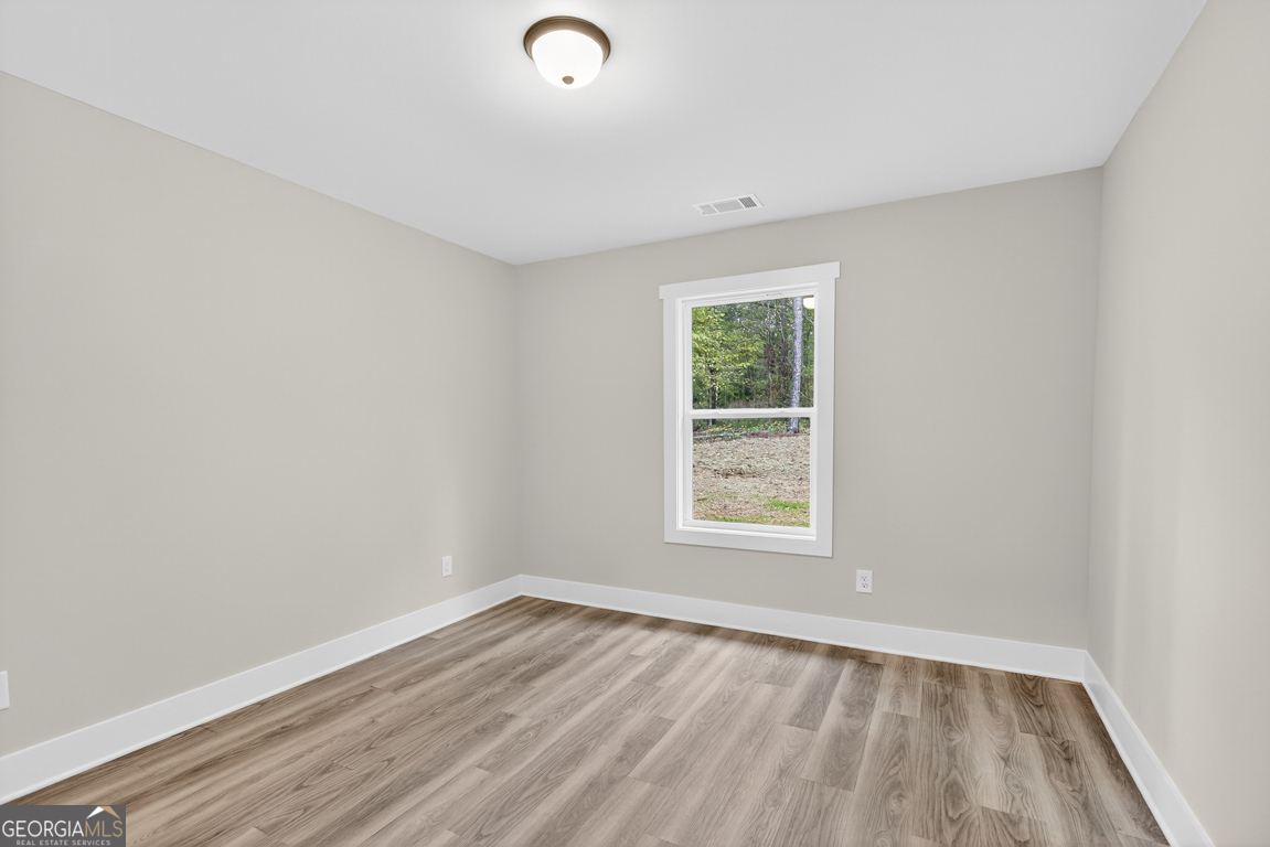 88 Mockingbird Lane, Unit 37 Winder, GA 30680 - Photo 12 of 40 an empty room with wooden floor and windows