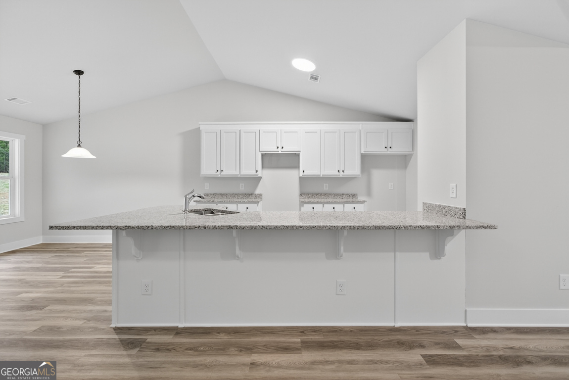 88 Mockingbird Lane, Unit 37 Winder, GA 30680 - Photo 18 of 40 a kitchen with stainless steel appliances granite countertop a sink a stove and a wooden floors