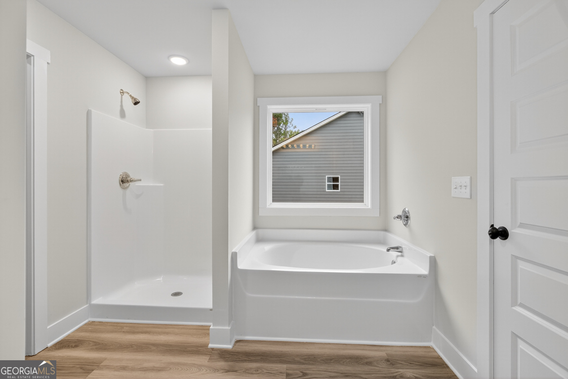 88 Mockingbird Lane, Unit 37 Winder, GA 30680 - Photo 35 of 40 a bathroom with a tub shower vanity and a sink
