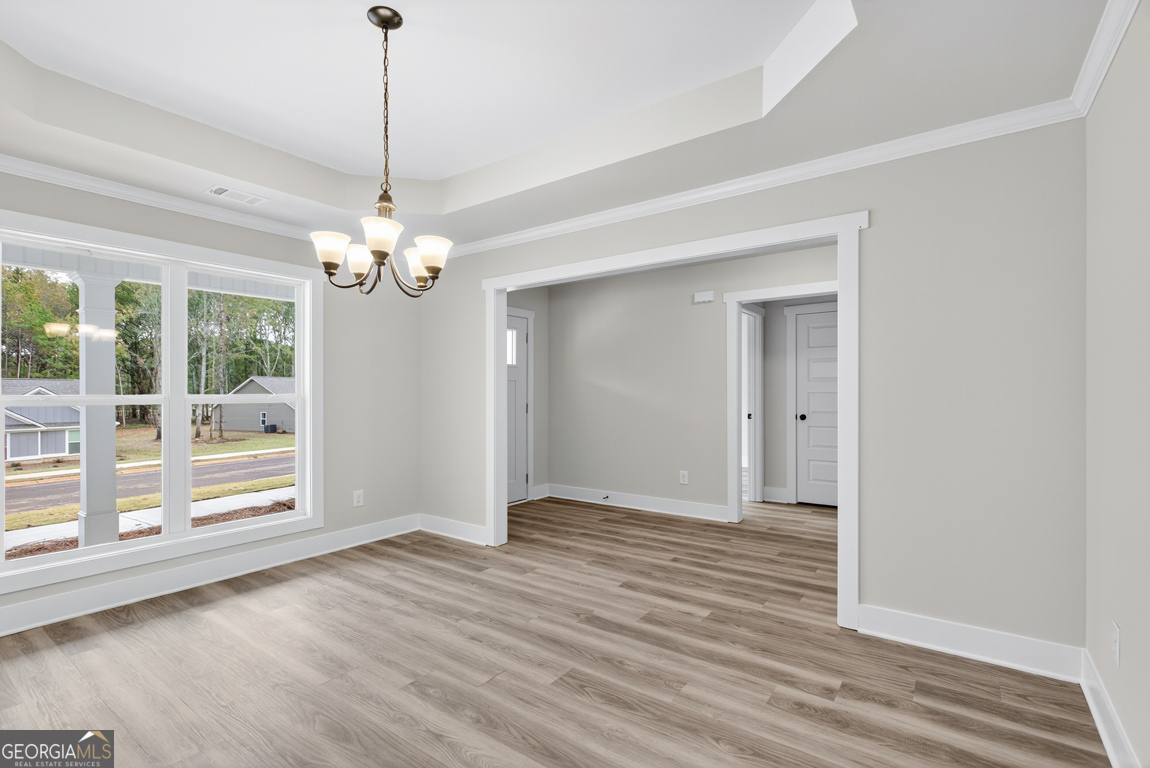 88 Mockingbird Lane, Unit 37 Winder, GA 30680 - Photo 5 of 40 a view of an empty room with wooden floor and a window