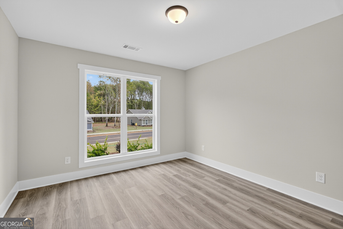 88 Mockingbird Lane, Unit 37 Winder, GA 30680 - Photo 7 of 40 wooden floor in an empty room with a window