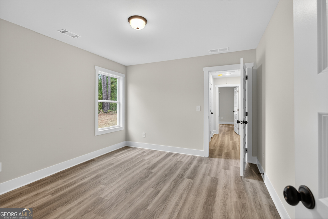 88 Mockingbird Lane, Unit 37 Winder, GA 30680 - Photo 9 of 40 wooden floor in an empty room with a window