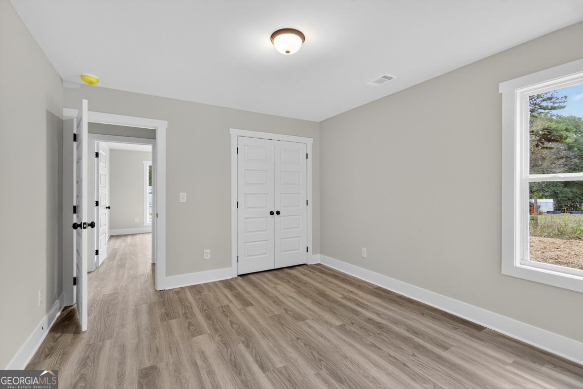 88 Mockingbird Lane, Unit 37 Winder, GA 30680 - Photo 10 of 40 wooden floor in an empty room with a window