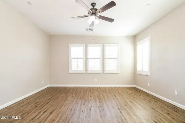 an empty room with wooden floor and windows