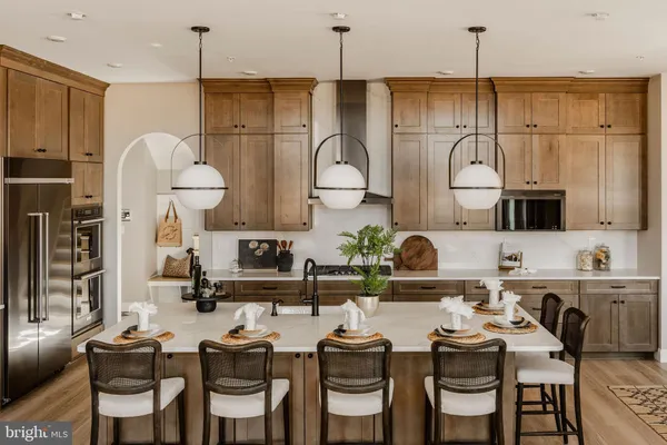 a kitchen with stainless steel appliances granite countertop a sink white cabinets and refrigerator